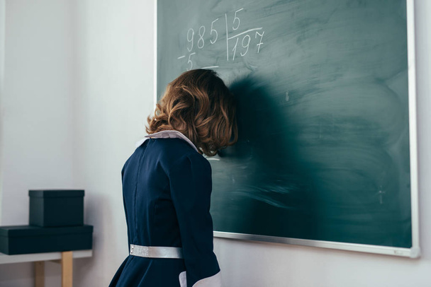 Školačka stojí s její čelo na tabuli - Fotografie, Obrázek