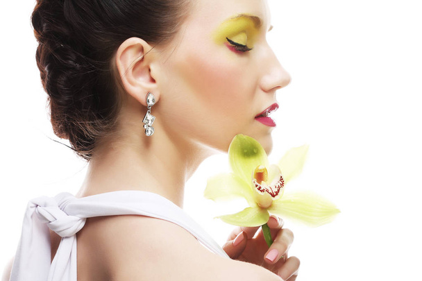 young woman with bright make up holding orchid - Фото, зображення