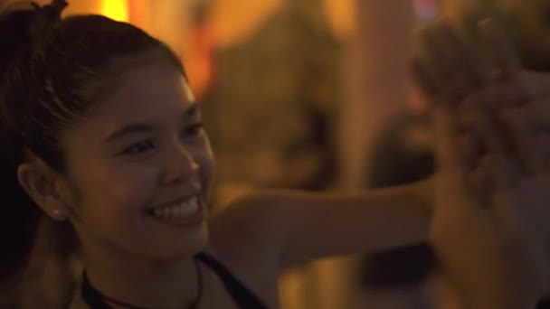 Smiling asian woman dancing together handsome man in hat. Couple in love dancing on dance party in night club. Cheerful having fun together. Romantic dance concept. - Filmagem, Vídeo