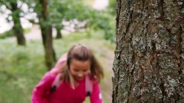 Girl walking into focus, hiking between trees in a forest, close up - Imágenes, Vídeo