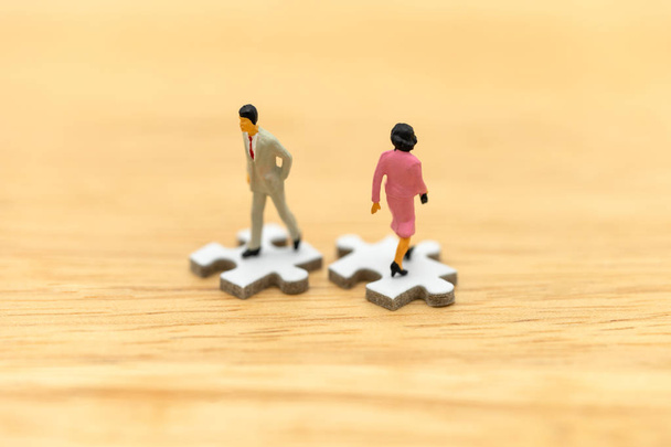 Miniature people businessmen standing on white Jigsaw. The concept used in selecting personnel to participate in the organization. with copy space. - Photo, Image