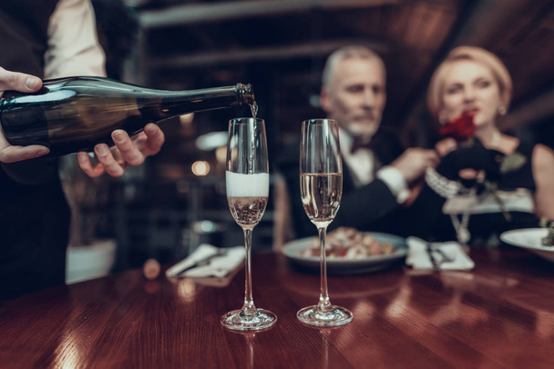 Businesswoman and Businessman . Old Business People .Successful Old People. Relax together. Romantic Meeting, Rich People. Couple Resting in Restaurant. Luxury Life. Waiter pouring champagne - 写真・画像