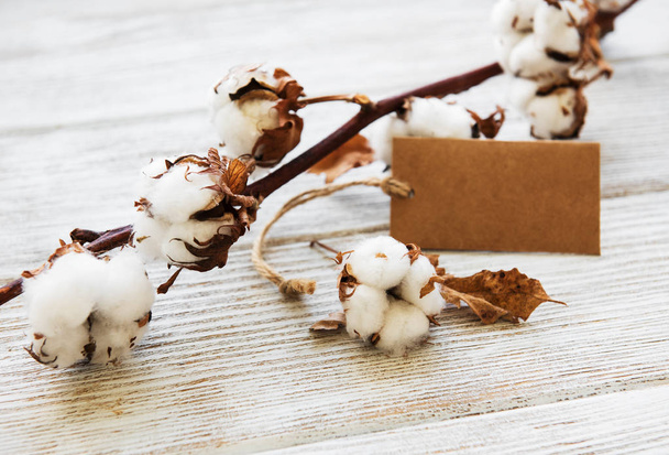 flor de algodón con etiqueta en una vieja mesa de madera
 - Foto, imagen