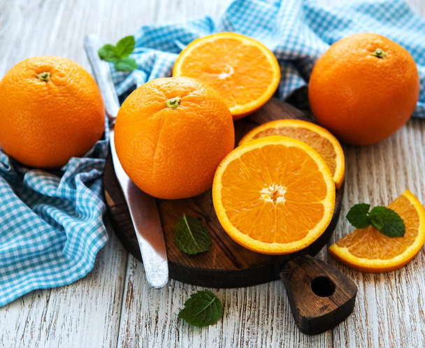 Vers oranje fruit op een oude witte houten tafel - Foto, afbeelding