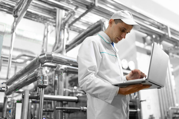 Technologist with a laptop in his hands at the dairy plant - Photo, Image