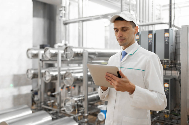 Süt fabrikasında onun elinde bir tablet ile teknoloji uzmanı - Fotoğraf, Görsel