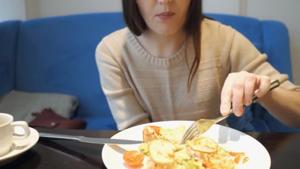 Άγνωστη νεαρή γυναίκα τρώει μια σαλάτα σε καφετέρια - Πλάνα, βίντεο