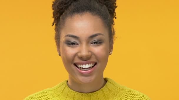 Positive afro-american woman holding donuts front of eyes, playful mood, joking - Imágenes, Vídeo