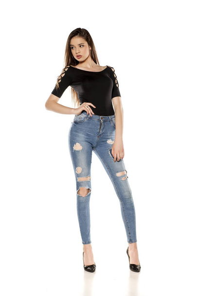 Young girl in ripped jeans on a white background - Fotoğraf, Görsel