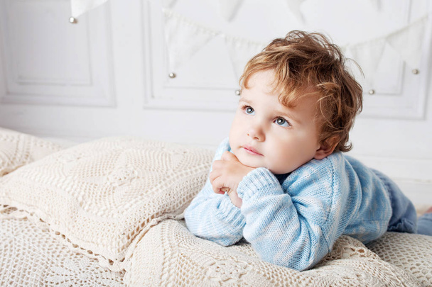 Portrait of happy adorable baby boy on the bed in his room. Copy space - Photo, Image
