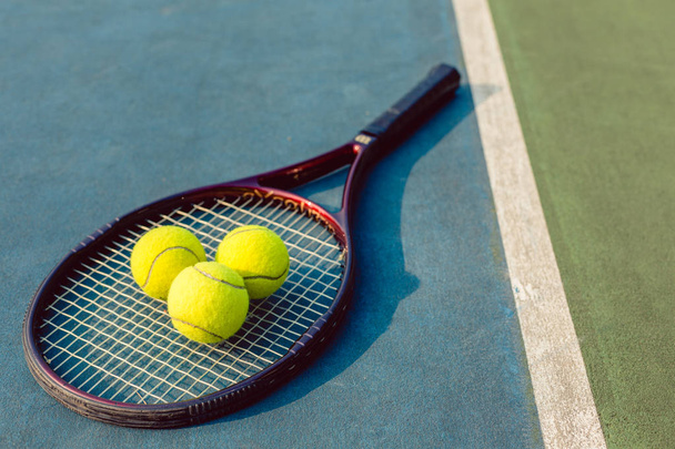 Γκρο πλαν υψηλός-γωνίας από τρεις μπάλες του τένις σε μια επαγγελματική ρακέτα - Φωτογραφία, εικόνα