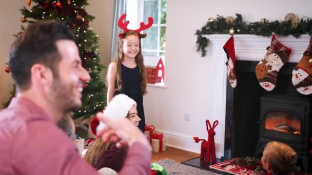 Multi-generation family playing charades as they gathering to celebrate Christmas at home together - shot in slow motion - Video, Çekim