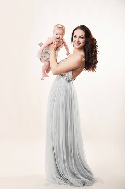 young attractive mother with a little girl on a light background - Photo, Image