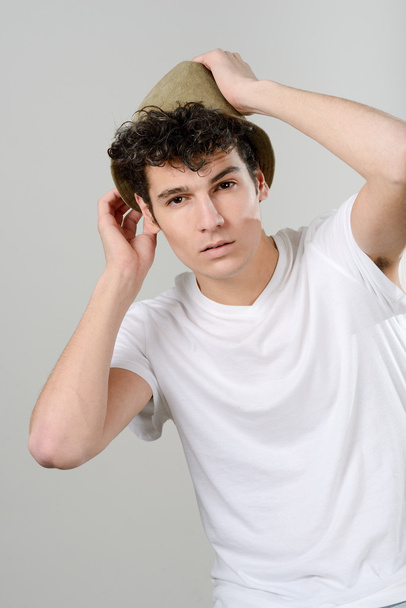 Csinos, fiatal férfi kalapot fehér háttér - Fotó, kép