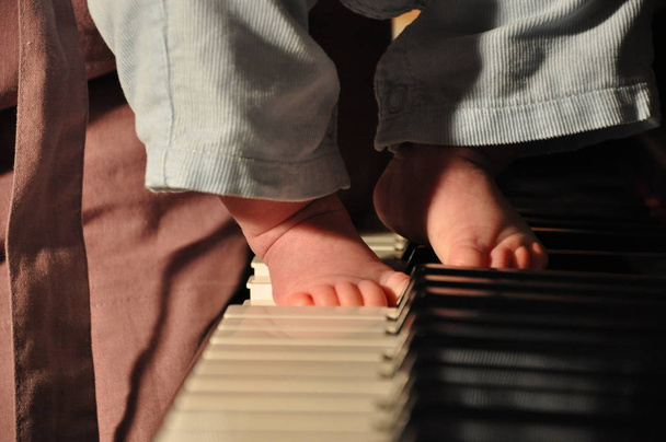 teclado de piano com pernas de criança, dia de mães
 - Foto, Imagem