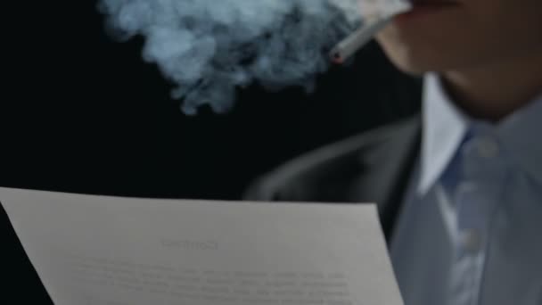 Persona nerviosamente fumando términos de contrato de lectura, fraude gángster, primer plano
 - Metraje, vídeo