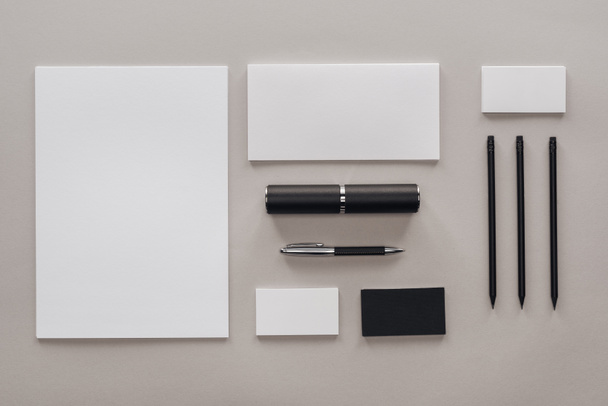 flat lay with blank white papers, cards and stationery on grey background - Foto, immagini