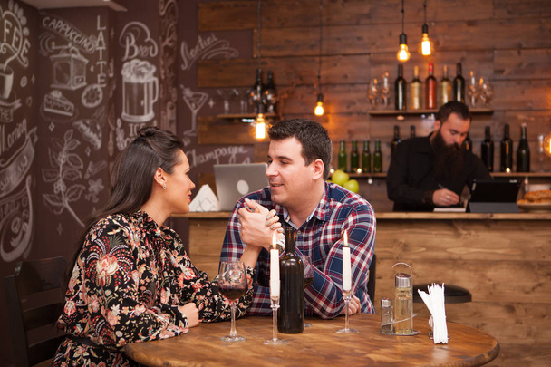 Kırmızı şarap içme bir hipster barda oturan bir tarihte çift. - Fotoğraf, Görsel