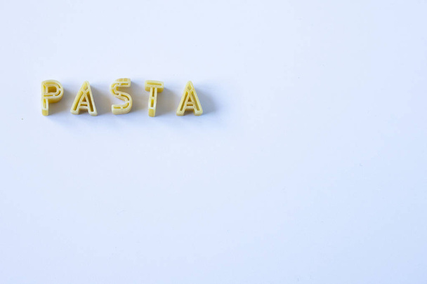 The word "pasta" composed with real pasta letters on a white surface. Background with copy space on the right side. - Photo, Image