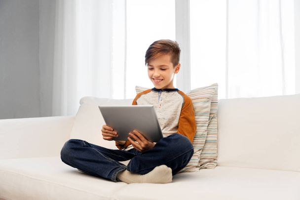 smiling boy with tablet pc computer at home - Zdjęcie, obraz