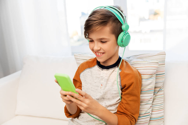 happy boy with smartphone and headphones at home - Foto, Imagem