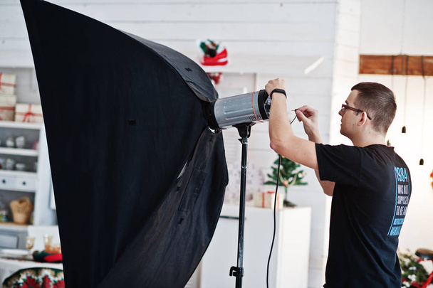 Photographer adjusts the flash light on studio.  - Photo, Image