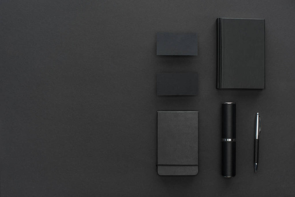 Notebooks, case, cards and pen on black background - Foto, Imagen