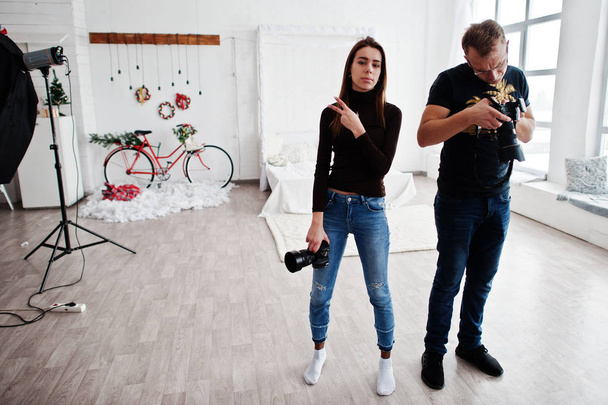 The team of two photographers looking at camera final work material on studio. - Foto, imagen