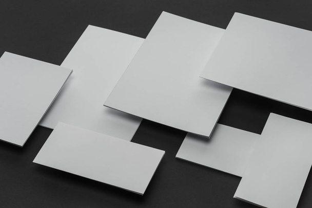 Pose plate avec des feuilles blanches de papier et de cartes sur fond noir
 - Photo, image