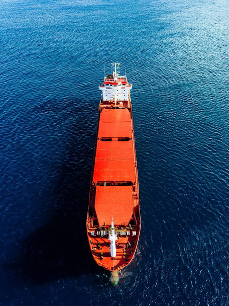 Aerial view of general cargo ship in blue sea in Italy. View from above of red empty container ship in the sea. - Photo, Image
