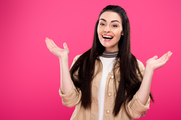 cheerful young woman gesturing with hands and smiling at camera isolated on pink  - Foto, Imagem