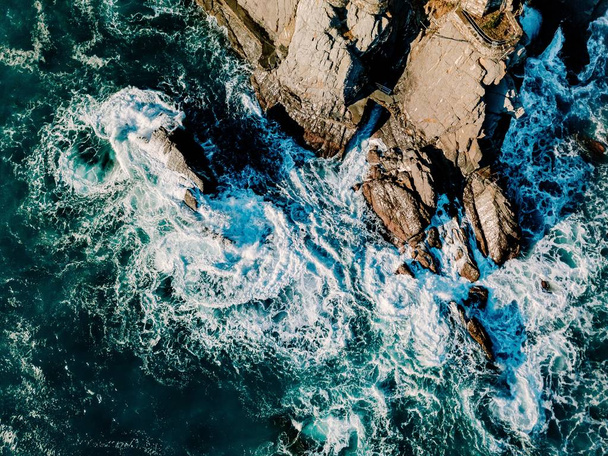 Aerial view of ocean waves and rocks. Blue and turquoise sea surface. - Photo, Image
