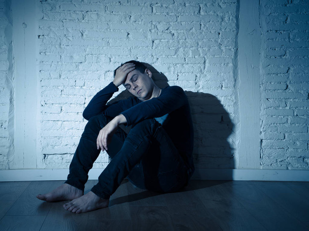 Portrait of sad depressed young man crying devastated feeling hurt suffering Depression in People, Sadness, Emotional pain, Loneliness and Heartbroken concept with copy space and dark mood light. - Фото, изображение