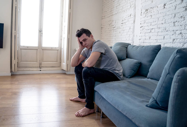 Portrait of young man felling depressed and desperate crying alone in sofa home suffering emotional pain and unhappiness. In People Broken heart, Bullying Depression and Mental health issues concept. - Foto, Bild