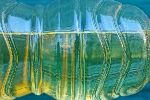 Teil einer klaren Plastikflasche mit gelbem Sonnenblumenöl - Foto, Bild