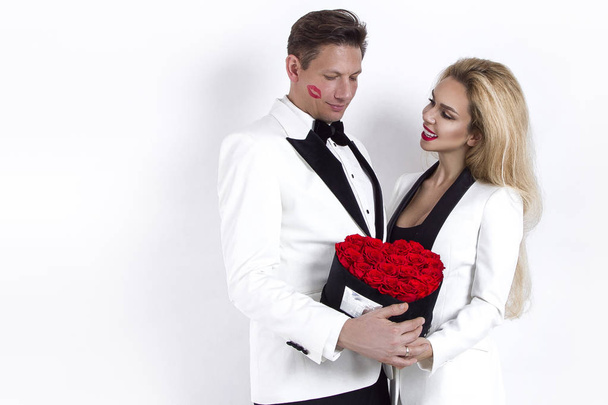 glückliches schönes Paar posiert auf weißem Hintergrund und hält Blumenkasten mit rotem Herz in der Hand. Valentinstag, Hochzeit - Bild - Foto, Bild