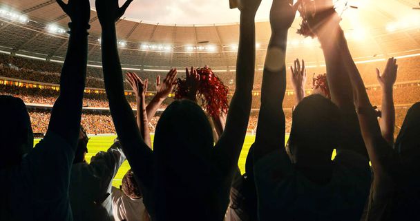 Eine Gruppe jubelnder Fans schaut sich eine Sportmeisterschaft im Stadion an. Ihre Mannschaft gewinnt und alle feiern dieses Ereignis. Die Menschen sind in lässige Kleidung gekleidet. - Foto, Bild