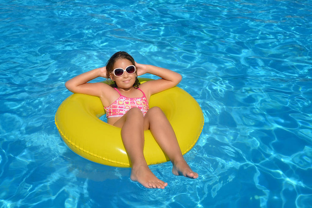 Prawdziwa urocza dziewczyna relaksująca się w basenie, letnia koncepcja wakacji - Zdjęcie, obraz