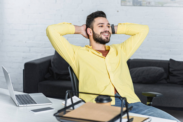 Cheerful bearded businessman with crossed arms looking away at office - Foto, Imagen