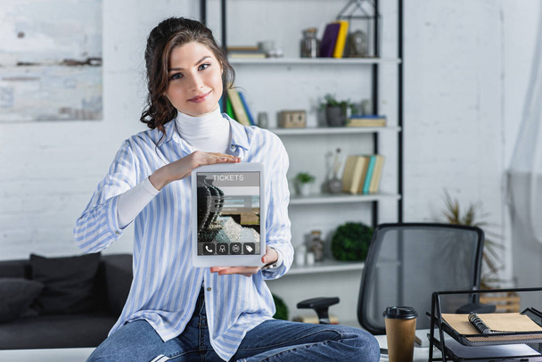 attractive woman holding digital tablet with tickets app on screen in modern office  - Fotoğraf, Görsel