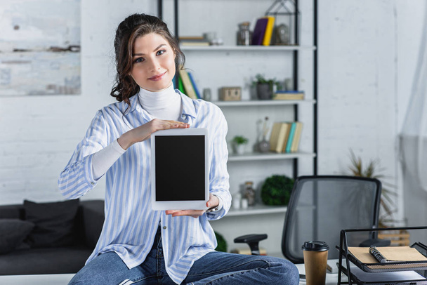 cheerful woman holding digital tablet with blank screen in modern office  - Foto, immagini