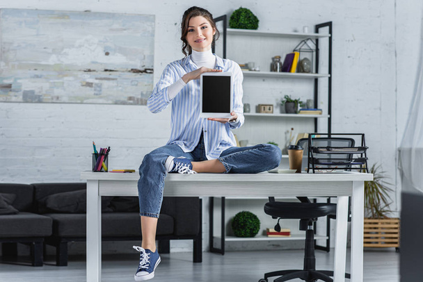 attractive woman holding digital tablet with blank screen while sitting on table in modern office  - Φωτογραφία, εικόνα