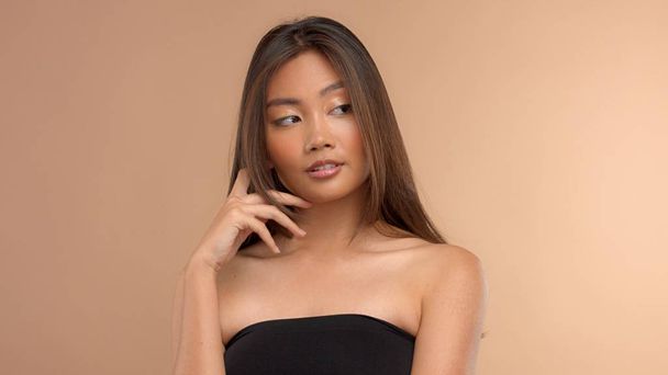 tailandés asiático modelo con natural maquillaje en beige fondo
 - Foto, Imagen
