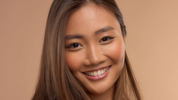 tailandés asiático modelo con natural maquillaje en beige fondo
 - Foto, Imagen