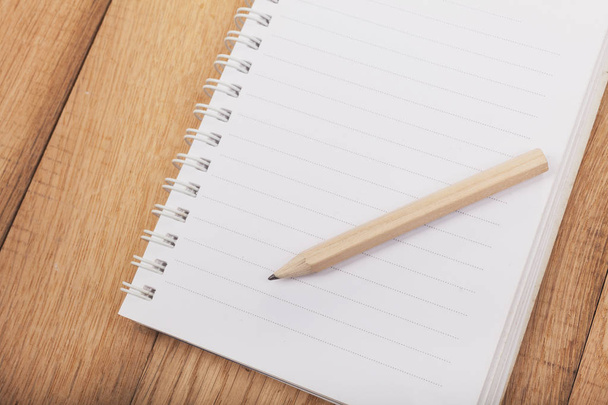 Открытая записная книжка (подкладка) с карандашом на деревянном фоне
 - Фото, изображение