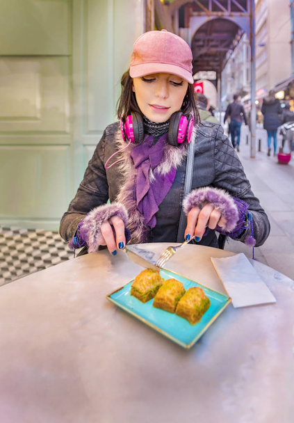 Bella turista viaggiatore donna mangia tradizionale dessert turco chiamato Baklava al caffè vicino alla Torre di Galata a Beyoglu, Istanbul, Turchia.Copia spazio per tex
 - Foto, immagini
