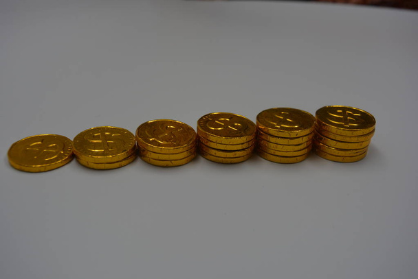 Monedas de oro con reflejo, valioso dinero de oro, centavos con hermoso color amarillo caro sobre un fondo blanco
 - Foto, imagen