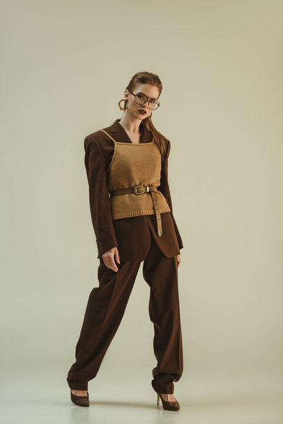 fashionable model posing in trendy retro clothing on beige - Fotó, kép
