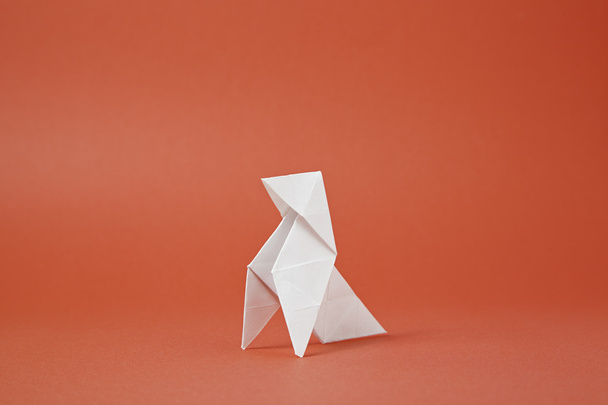 Origami pájaro de papel sobre un fondo rojo
 - Foto, imagen