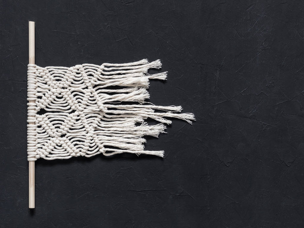 Macrame. Macrame weaving. White thread, black background, closeup - Foto, afbeelding